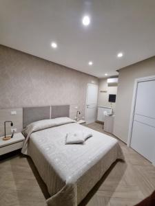 ein Schlafzimmer mit einem großen Bett und zwei Tischen mit Lampen in der Unterkunft Nonno Umberto Apartments in Pompei