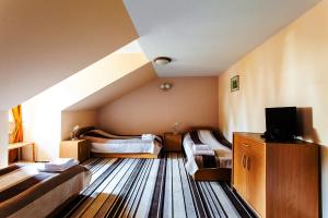 クラシチンにあるザメック フ クラシチニエのベッド2台とテレビが備わる客室です。