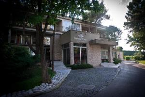 ein Gebäude mit einem Baum davor in der Unterkunft GRANDE CASA Hotel - Međugorje in Međugorje