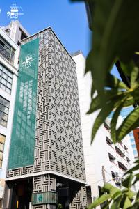 un edificio alto con un cartel en el costado en Aroma Chew Hotel, en Taichung