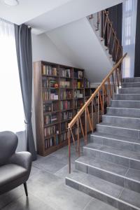 a staircase with bookshelves in a living room at Vila Greta by Hotel Ramonda in Rtanj