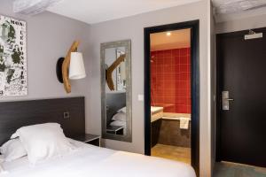 a bedroom with a bed and a bathroom with a shower at Hotel Le Dauphin in Honfleur