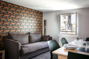 a living room with a couch and a table at Hotel Le Dauphin in Honfleur