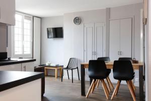 a kitchen and dining room with a table and chairs at Hotel Le Dauphin in Honfleur