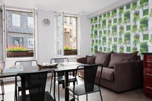 a living room with a couch and a table at Hotel Le Dauphin in Honfleur