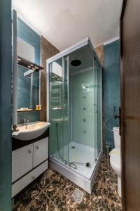 uma casa de banho com um chuveiro, um lavatório e um WC. em Suru Hotel & Restaurant em Buşteni