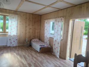 a bedroom with a bed in a room with wooden walls at Przy Trójstyku in Dubeninki