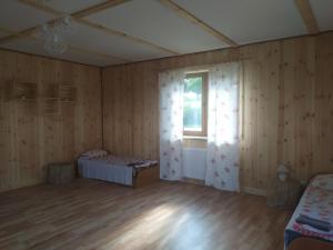 una camera da letto con pareti in legno e finestra di Przy Trójstyku a Dubeninki