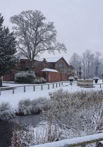 a park covered in snow in front of a building at Bredbury Hall Hotel in Stockport