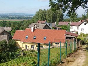 a house with red roofs behind a fence at MotoHostel Wolter - apartmán Leme in Všeň