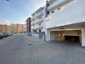 a parking lot next to a building with a parking garage at Apartament Nice Stay in Lubin