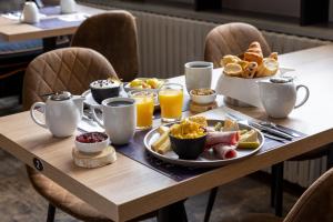 a table with breakfast foods and coffee on it at Hotel Le Dauphin in Honfleur +46 photos