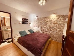 a bedroom with a bed and a stone wall at Guesthouse F in Split