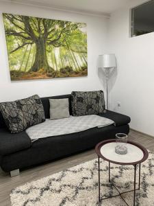 a living room with a black couch and a table at Hidden Apartment in Miercurea-Ciuc