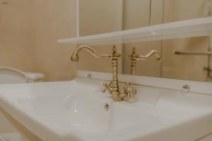 un lavandino del bagno con un rubinetto e uno specchio di IREPALACE Goderdzi a Goderdzi