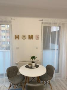 uma mesa e cadeiras num quarto com uma placa na parede em Apartament Nice Stay em Lubin