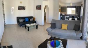a living room with two couches and a kitchen at Sirena Sunrise 120 in Paphos City