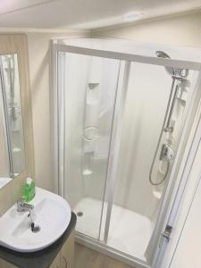 a bathroom with a shower and a sink at NB12 Entire Caravan - Newquay in Newquay Bay Resort