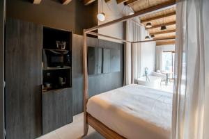 ein Schlafzimmer mit einem Himmelbett und einem TV in der Unterkunft Mochoruralhome matarraña suite in Beceite