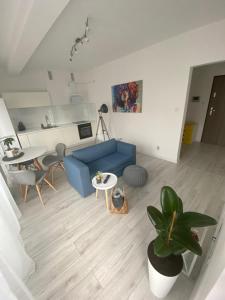 uma sala de estar com um sofá azul e uma mesa em Apartament Nice Stay em Lubin