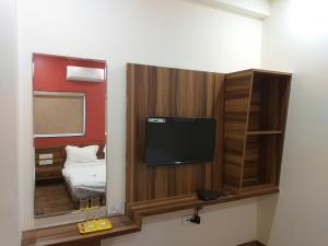 a small room with a tv and a mirror at Hotel the grand shiva in Gondal +23 photos