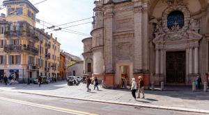 un grupo de personas caminando delante de un edificio en La casa di Alice, en Parma