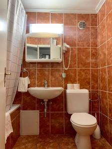 
a bathroom with a toilet, sink, and bathtub at Hotel Balzac in Geneva
