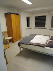 a bedroom with a bed and a cabinet and a chair at Ferienwohnung Berger in Greven