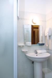 Baño blanco con lavabo y espejo en Hotel Chalet del Lago, en Avigliana