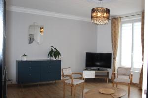 a living room with a tv and a blue dresser at Maison LC in Cramant