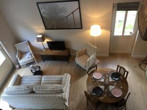 ein Wohnzimmer mit einem Sofa und einem Tisch in der Unterkunft Le Clos de Jabanelle in Ciney