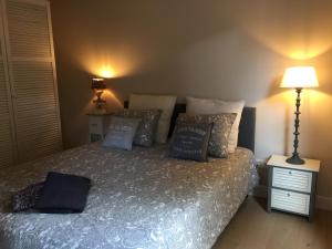 a bedroom with a bed with pillows on it at Le Clos de Jabanelle in Ciney