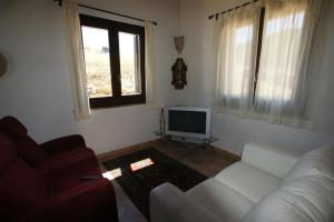 a living room with a white couch and a television at Cottage Bruca in Brucanuova