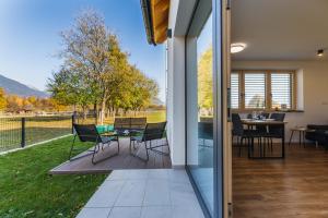 a glass door leading to a patio with a table and chairs at Maple & Pine Bled in Bled