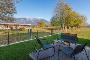 eine Terrasse mit Stühlen, einem Tisch und einem Zaun in der Unterkunft Maple & Pine Bled in Bled