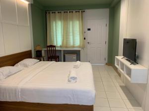 1 dormitorio con 1 cama grande y TV en CHADA HOUSE, en Chiang Mai