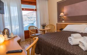 Cette chambre comprend un lit, un bureau et une fenêtre. dans l'établissement Hotel Chalet del Lago, à Avigliana