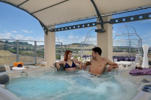 a man and a woman sitting in a hot tub at Hotel Nuovo Diana in Senigallia