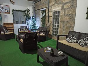 a living room with chairs and green carpet at Casa da Belavista in Trofa
