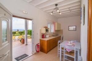 a kitchen with a table and a dining room at Beachside Bungalows Acharavi Corfu in Acharavi +80 photos