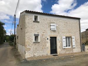een klein wit bakstenen huis met een zwarte deur bij Essai de chaille in Surgères