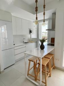 Una cocina blanca con una mesa y sillas blancas. en Costa Ballena Terrace Beach House, en Costa Ballena