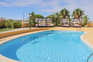 a large swimming pool with two chairs around it at Quinta Nova Vale Del Rey in Carvoeiro