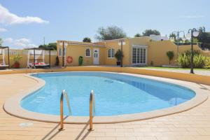 a pool in a yard with a house in the background at Quinta Nova Vale Del Rey in Carvoeiro