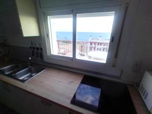 a kitchen with a sink and a window with a view at terraza al mar in Pineda de Mar +60 photos