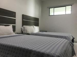 two beds in a bedroom with a window at Hotel Boutique San Rafael in Mariquita