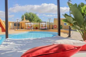 a pool with a bed in front of a building at Quinta Nova Vale Del Rey in Carvoeiro