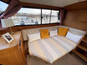 einen Sitz auf der Rückseite eines Bootes mit Fenster in der Unterkunft TraumZeitBoot Amavida Yacht auf dem Scharmützelsee Bad Saarow in Bad Saarow