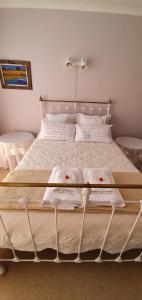 ein weißes Bett mit weißer Bettwäsche und roten Kirschen darauf in der Unterkunft Hinterheim in Lambertʼs Bay