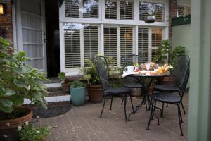 Carmel Garden Inn في كرمل: طاولة وكراسي على فناء به نباتات